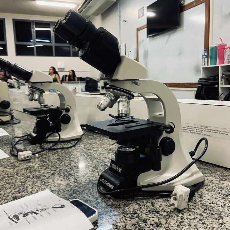 what is the proper way to carry a microscope